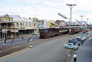 c1962 - Ellen Street - Port Pirie - loco SAR 900 on passenger train in street with Brill 75 class railcar alongside